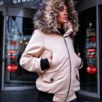 Заказать в подарок женскую зимнюю куртку с капюшоном и карманами светло-бежевого цвета оптом Украина