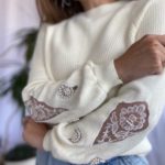 Замовити молочний жіночий светр щільної в'язки з прикрасою на осінь дешево